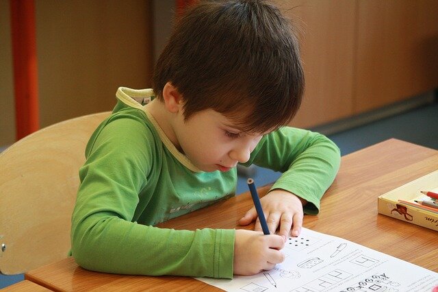 Uczeń w szkole - pisanie w ławce